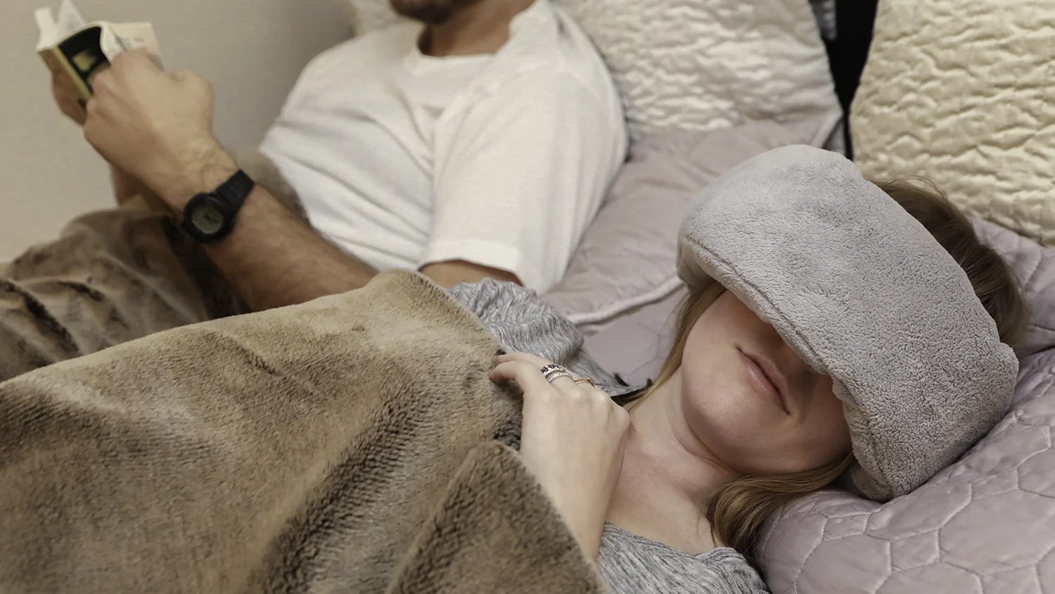A couple relaxing, one wearing the Wrap-a-Nap